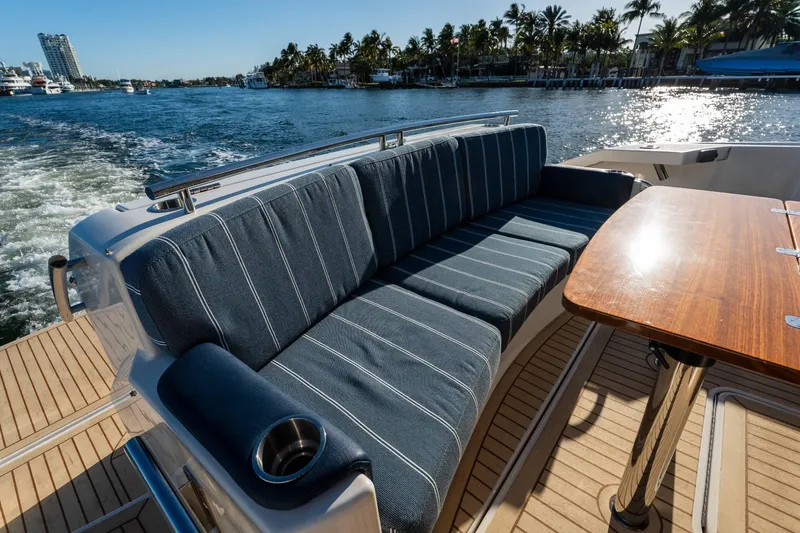 Down Time Yacht Photos Pics Luxurious seating area on 2015 Tiara Yachts C44 Coupe, with ocean view and wooden table.