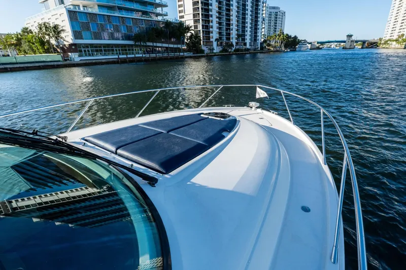 Down Time Yacht Photos Pics 2015 Tiara Yachts C44 Coupe cruising near waterfront buildings.