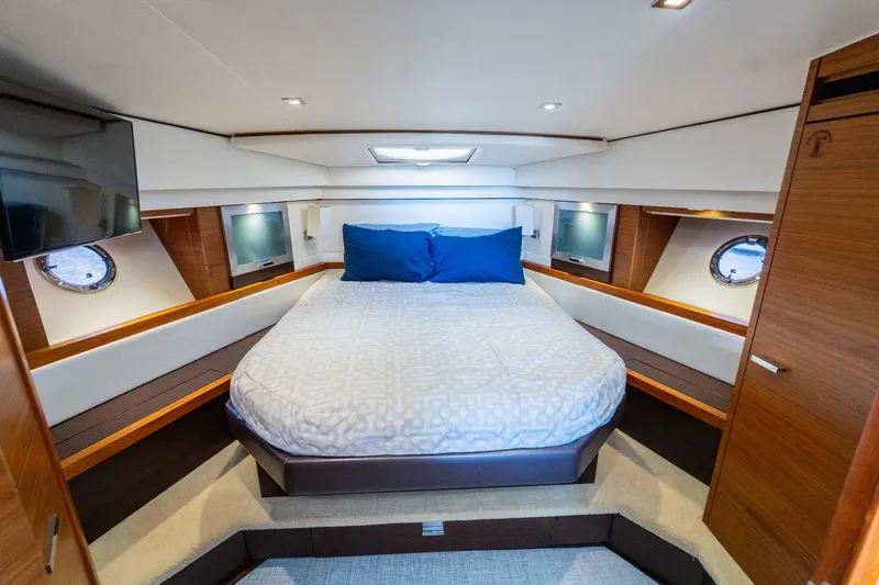 Down Time Yacht Photos Pics Luxurious bedroom interior of 2015 Tiara Yachts C44 Coupe with circular bed and porthole windows.