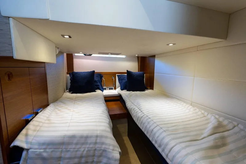 Down Time Yacht Photos Pics Twin beds in the 2015 Tiara Yachts C44 Coupe cabin, featuring cozy bedding and ambient lighting.