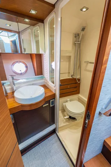 Down Time Yacht Photos Pics Luxurious bathroom in 2015 Tiara Yachts C44 Coupe with modern fixtures and wood accents.