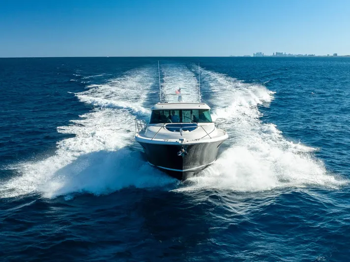 Down Time Yacht Photos Pics 2015 Tiara Yachts C44 Coupe cruising on open ocean, creating a dynamic water trail.