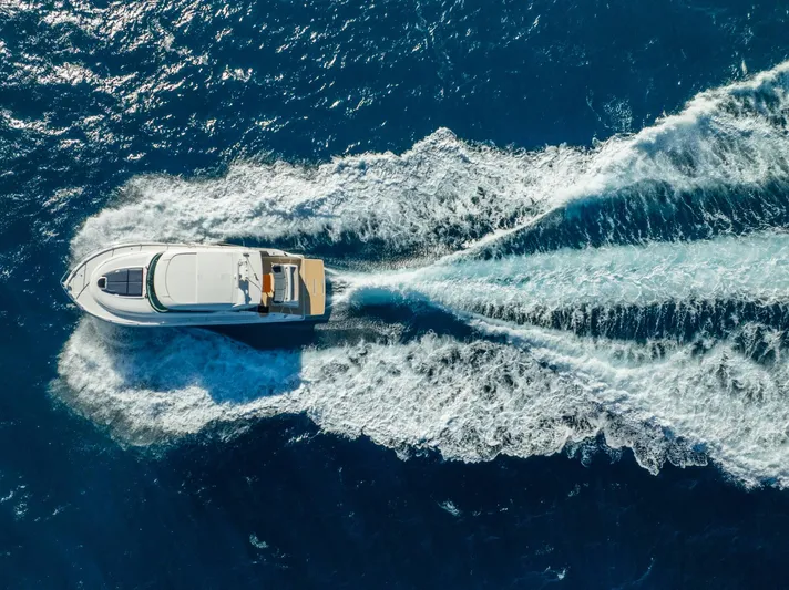 Down Time Yacht Photos Pics Aerial view of 2015 Tiara Yachts C44 Coupe cruising on open blue sea.