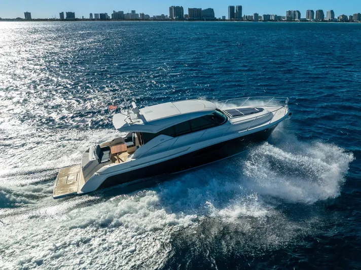 Down Time Yacht Photos Pics 2015 Tiara Yachts C44 Coupe cruising on open water near city skyline.