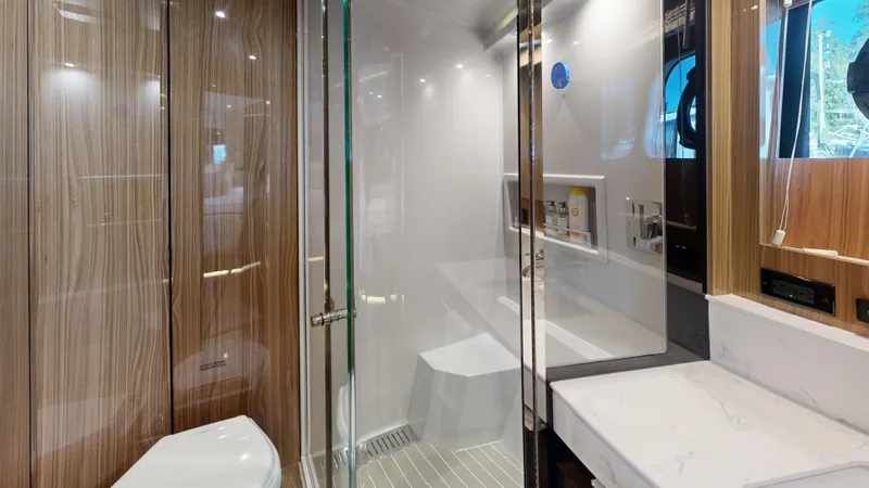  Yacht Photos Pics Luxurious bathroom interior of 2021 Cruisers Yachts 60 Cantius with modern fixtures and wood accents.