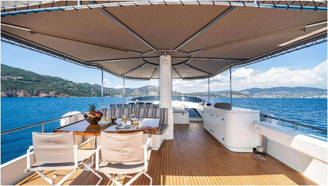 Luxurious Explorer trawler 67-70' yacht deck with dining area, ocean view, and canopy, 2012 model.