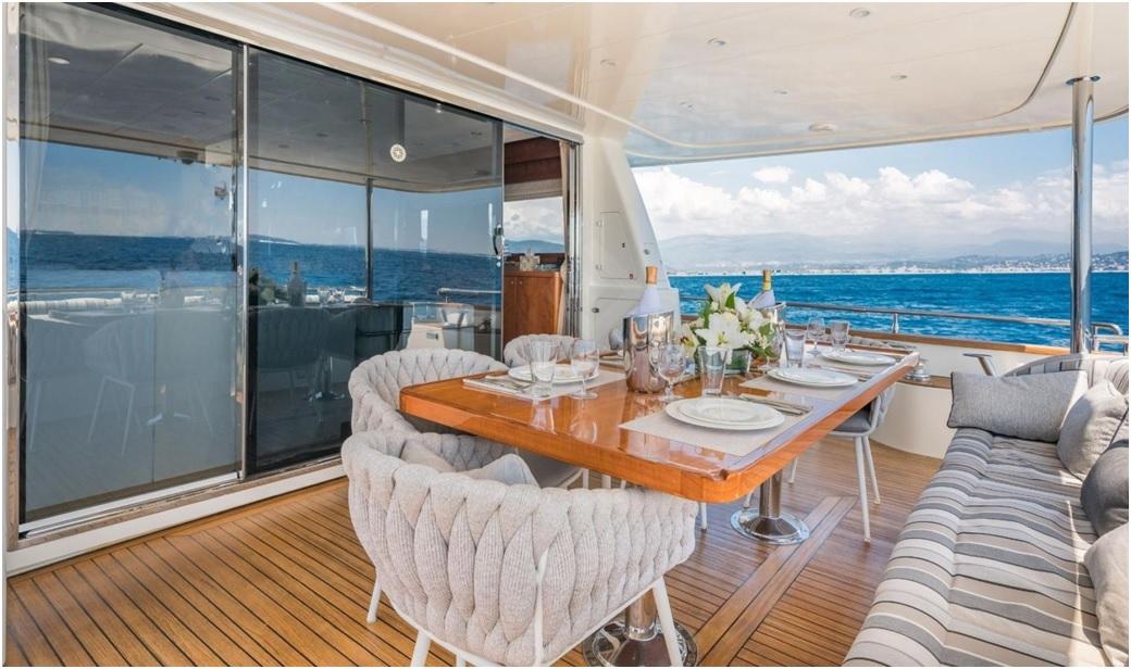 Luxurious Explorer trawler 67-70' yacht deck with elegant dining setup, ocean view, 2012 model.