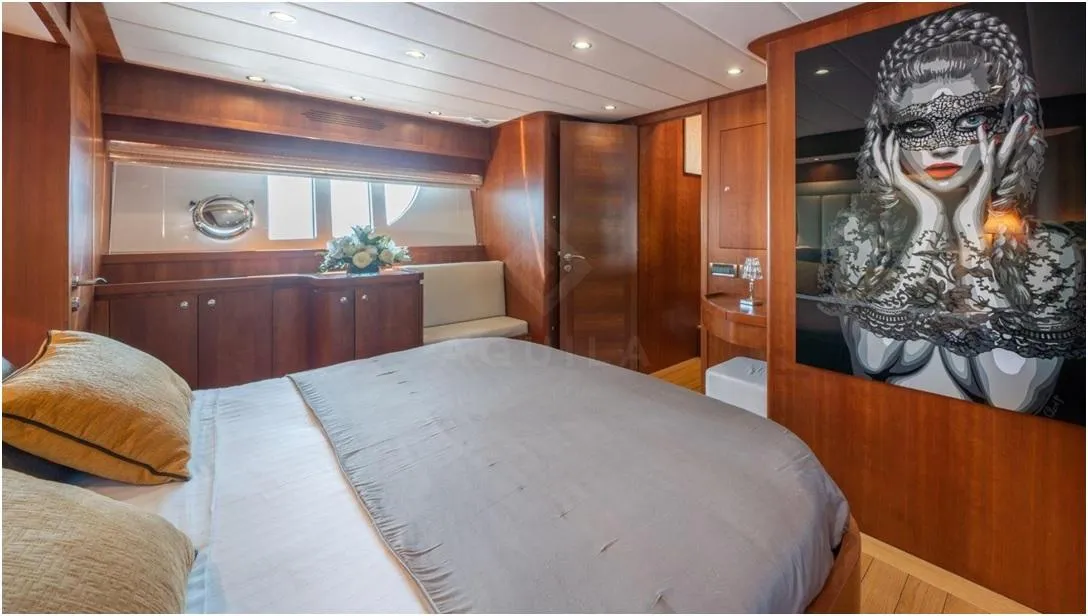 Luxurious bedroom in 2012 Explorer Trawler 67-70', featuring elegant wood paneling and modern art.