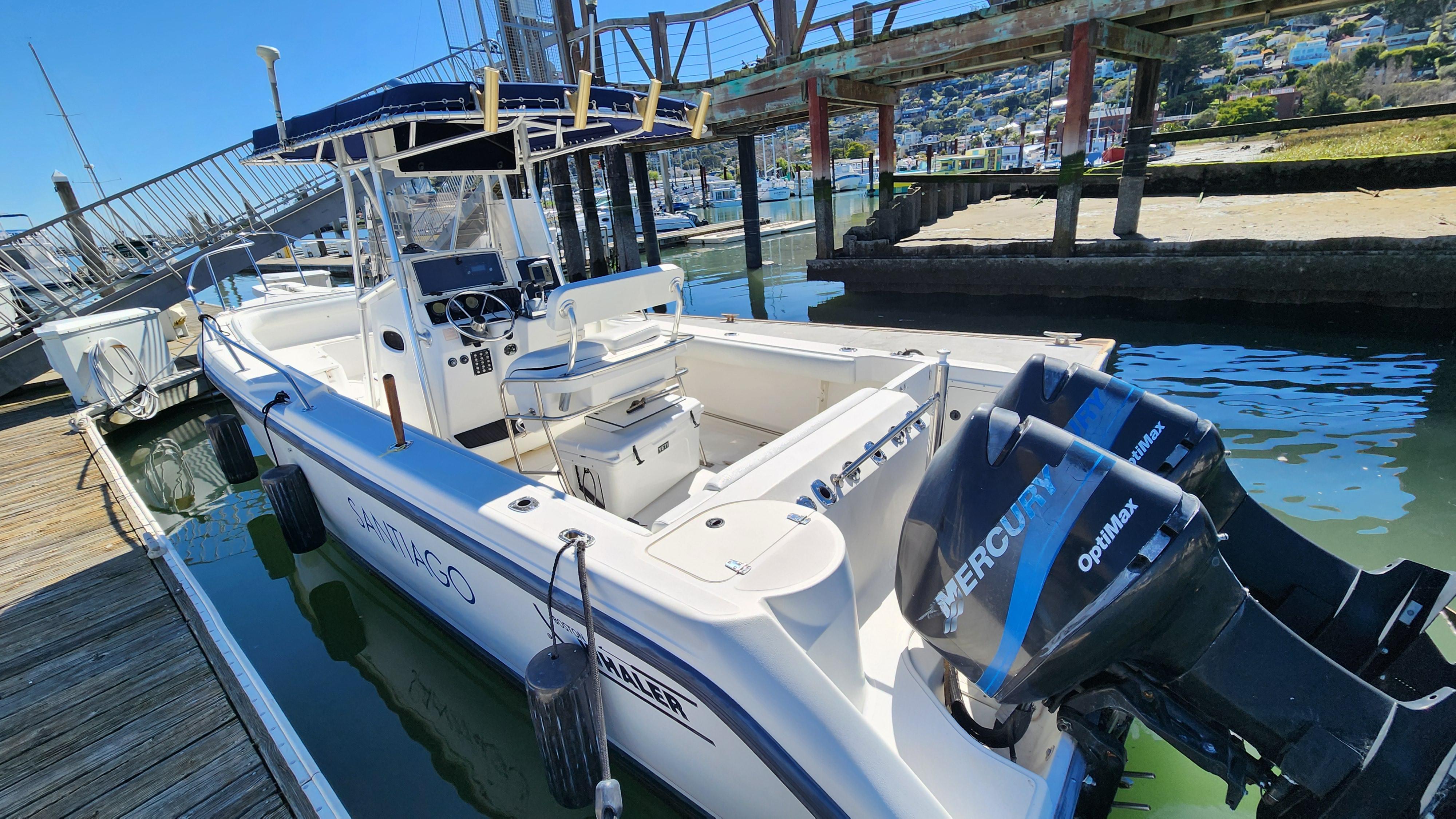 2001 Boston Whaler 26 Outrage boat docked with twin Mercury engines.