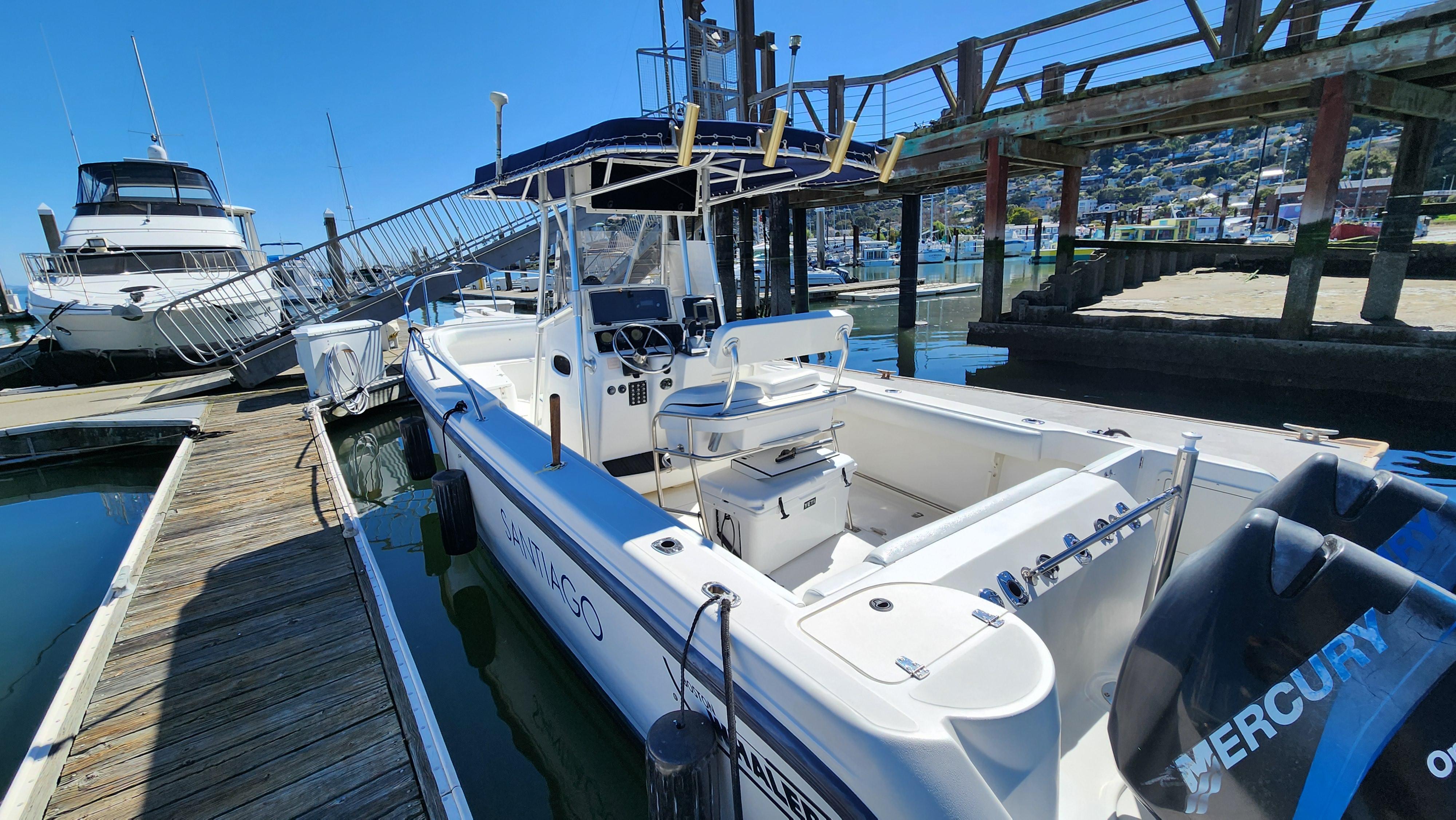 2001 Boston Whaler 26 Outrage docked at marina, featuring spacious deck and Mercury engine.