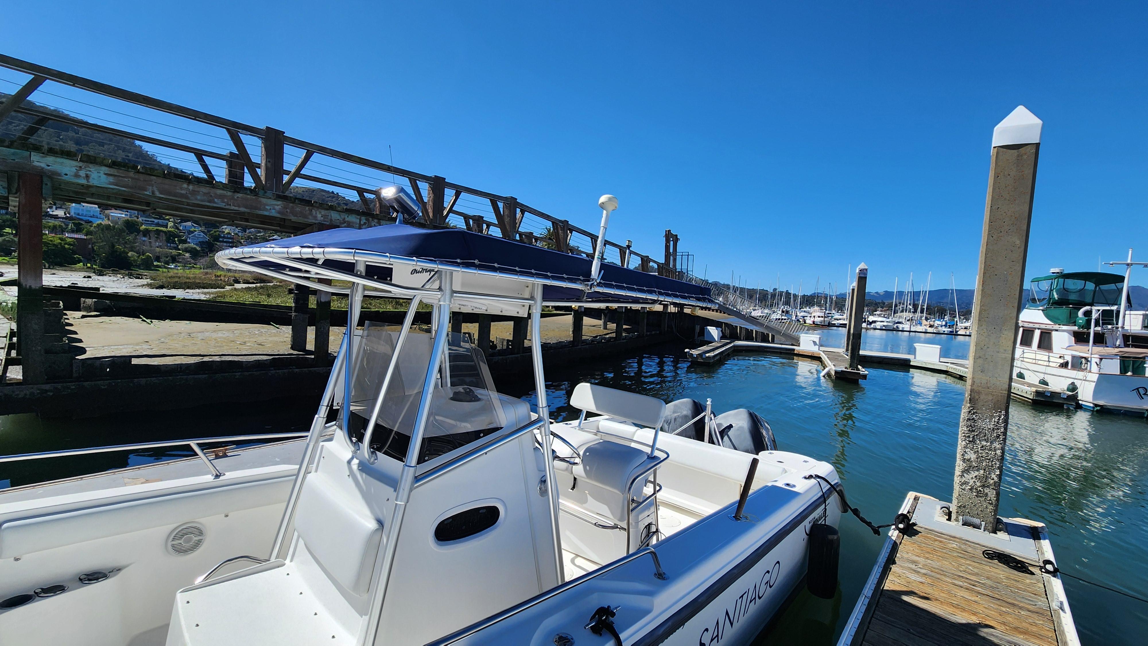Boston Whaler 26 Outrage 2001 docked at marina under clear blue sky.