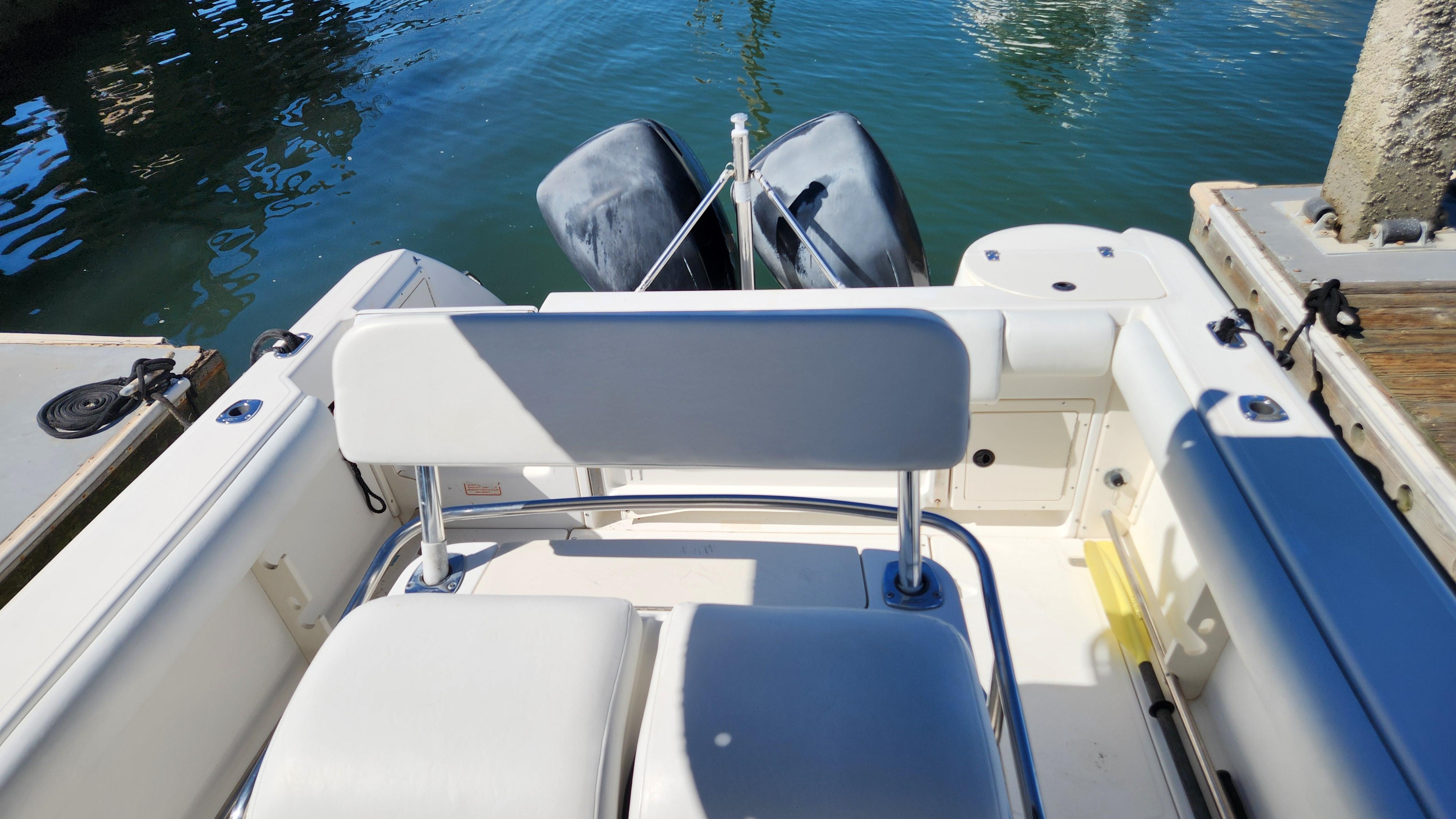 2001 Boston Whaler 26 Outrage boat interior with dual outboard motors at dock.