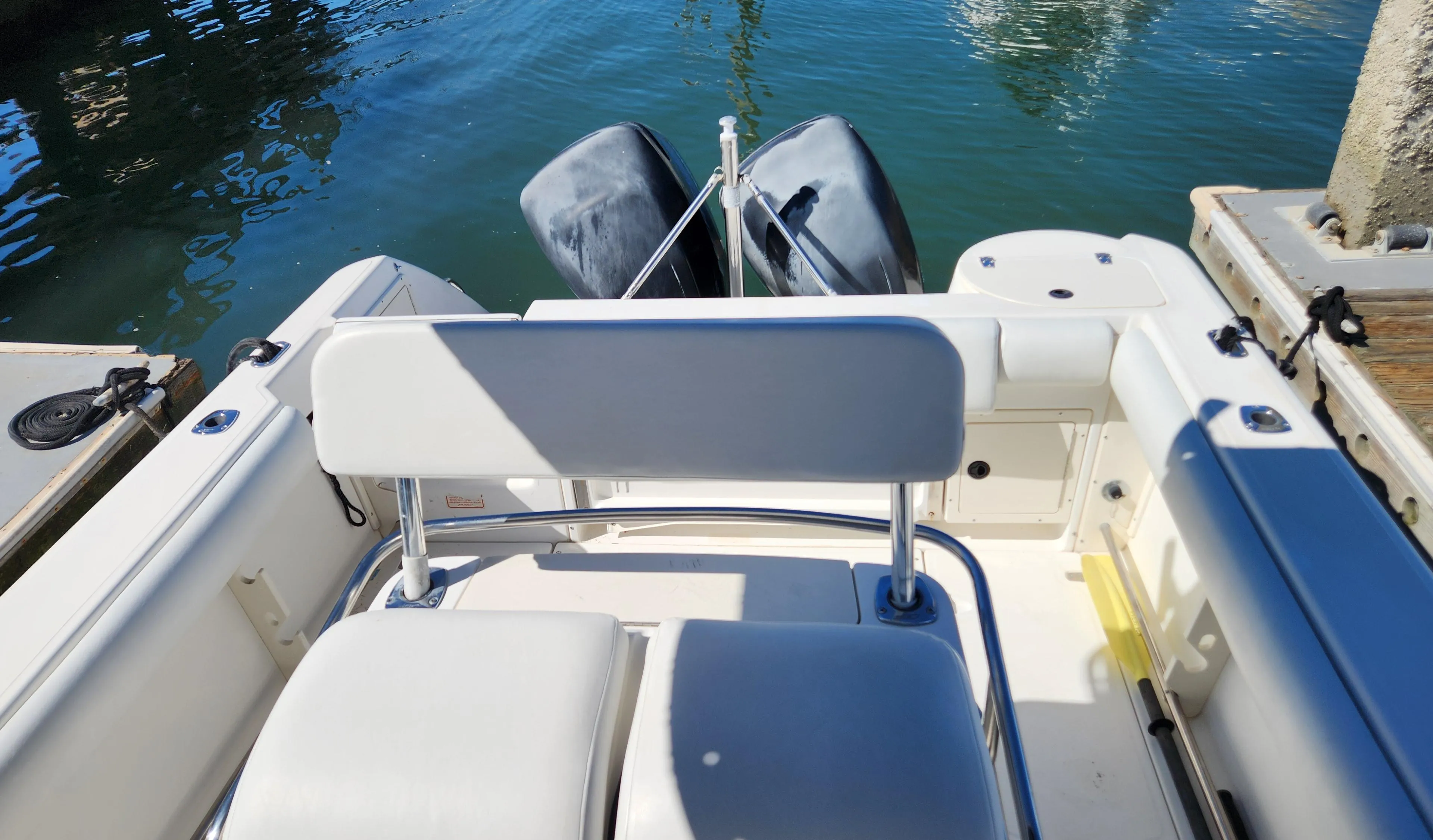 2001 Boston Whaler 26 Outrage boat interior with dual outboard motors at dock.