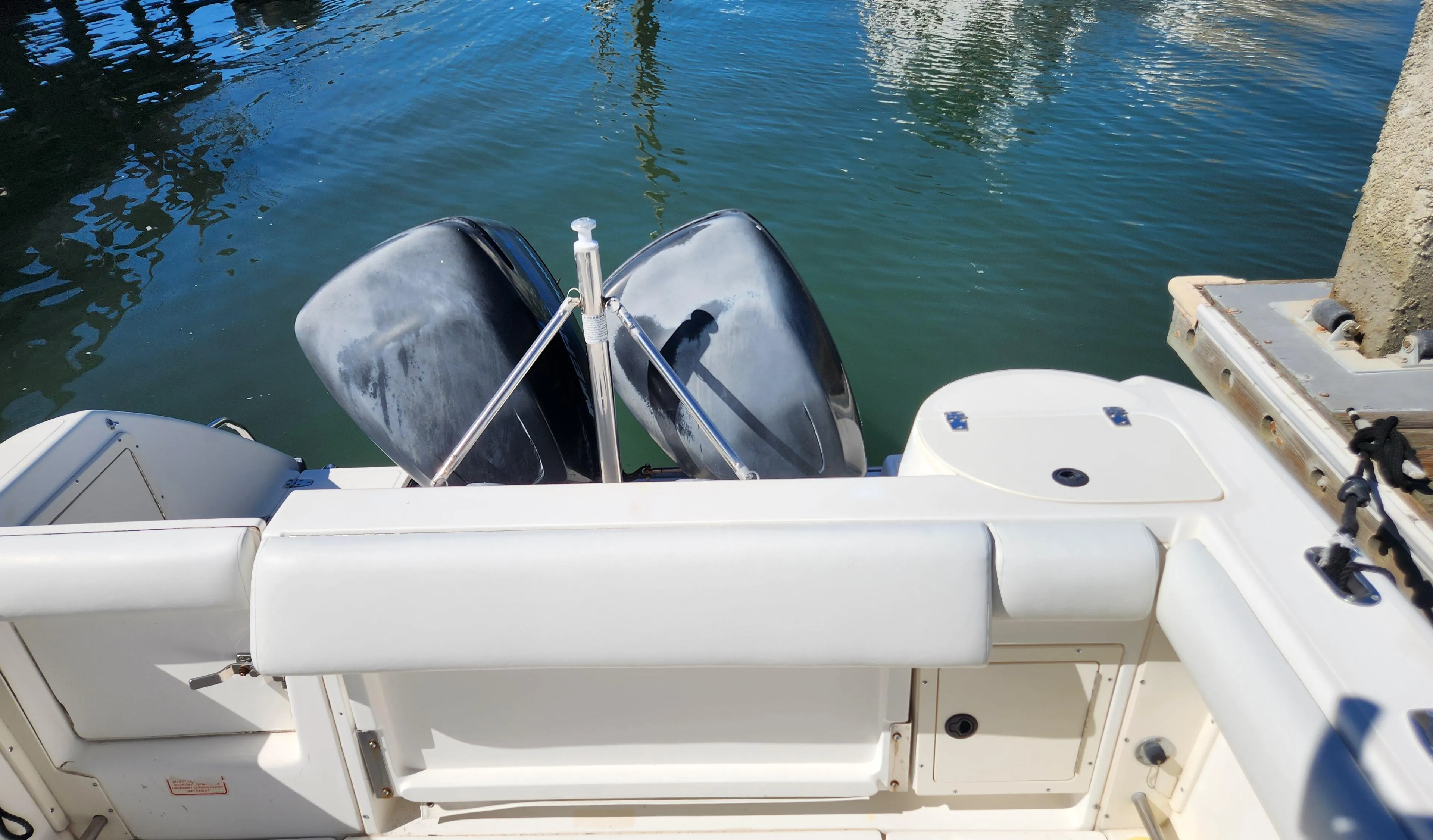 2001 Boston Whaler 26 Outrage boat with dual outboard motors on calm water.