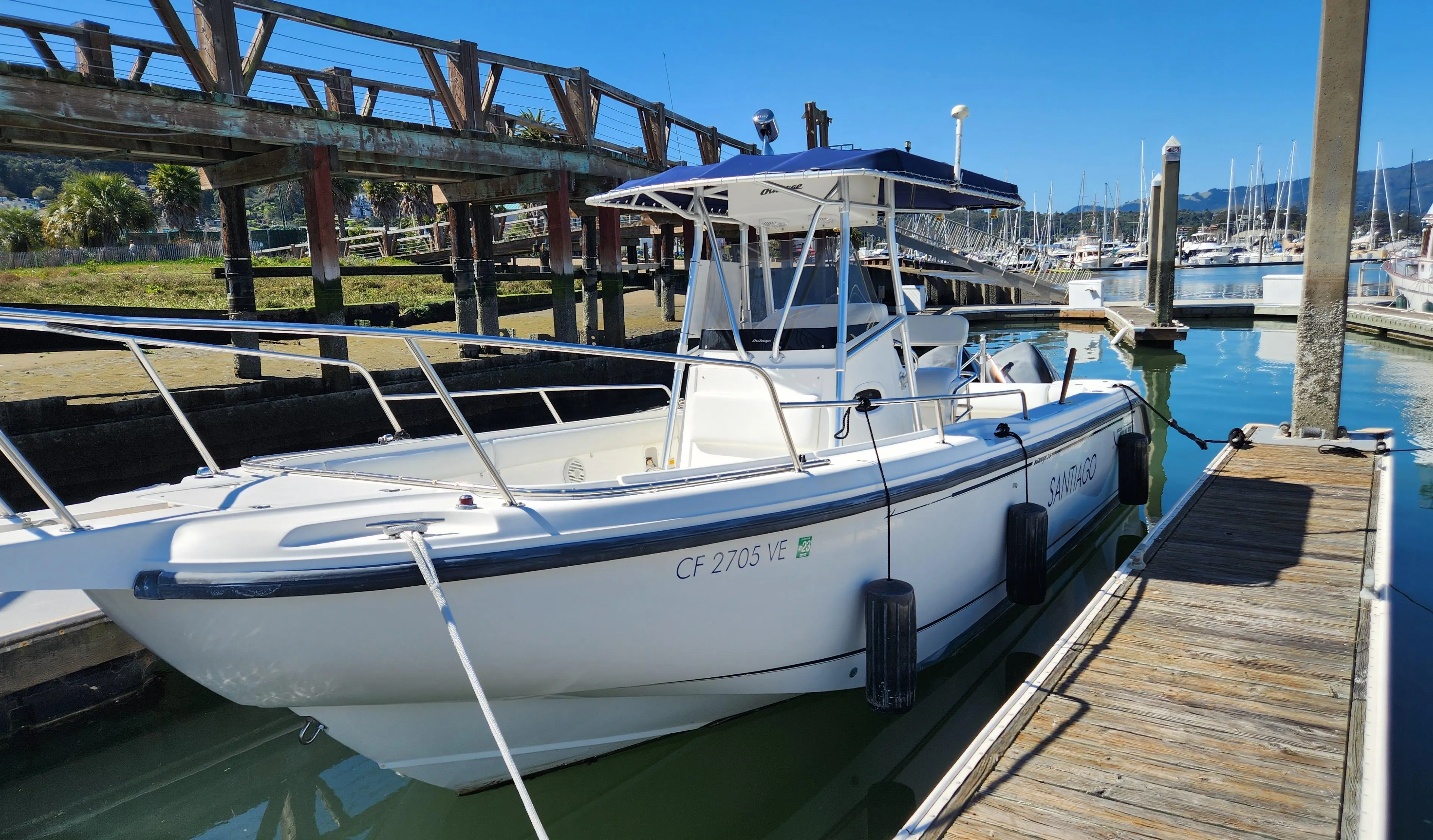 2001 Boston Whaler 26 Outrage boat docked at marina under clear blue sky.