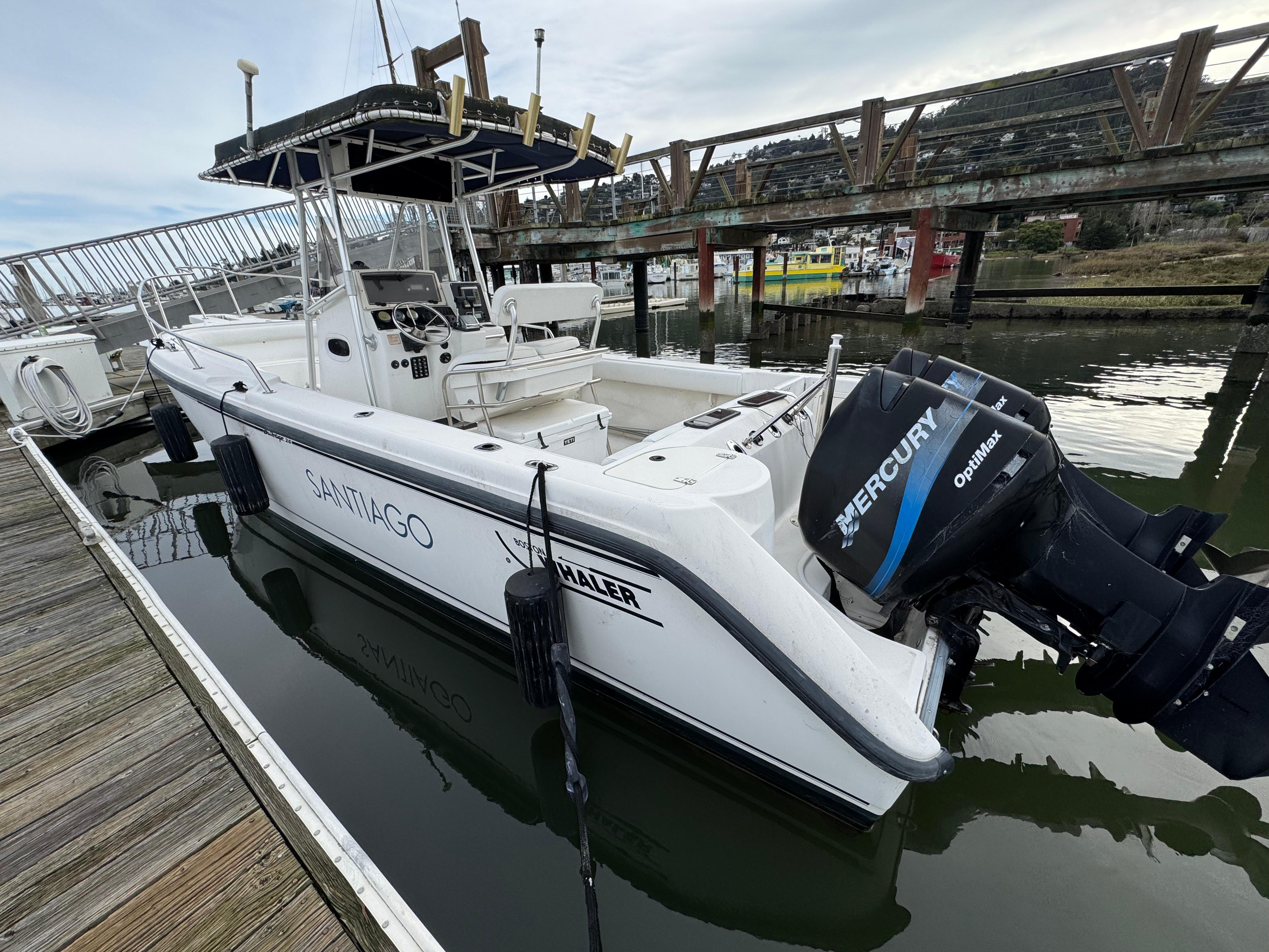 2001 Boston Whaler 26 Outrage boat docked with Mercury outboard engine.