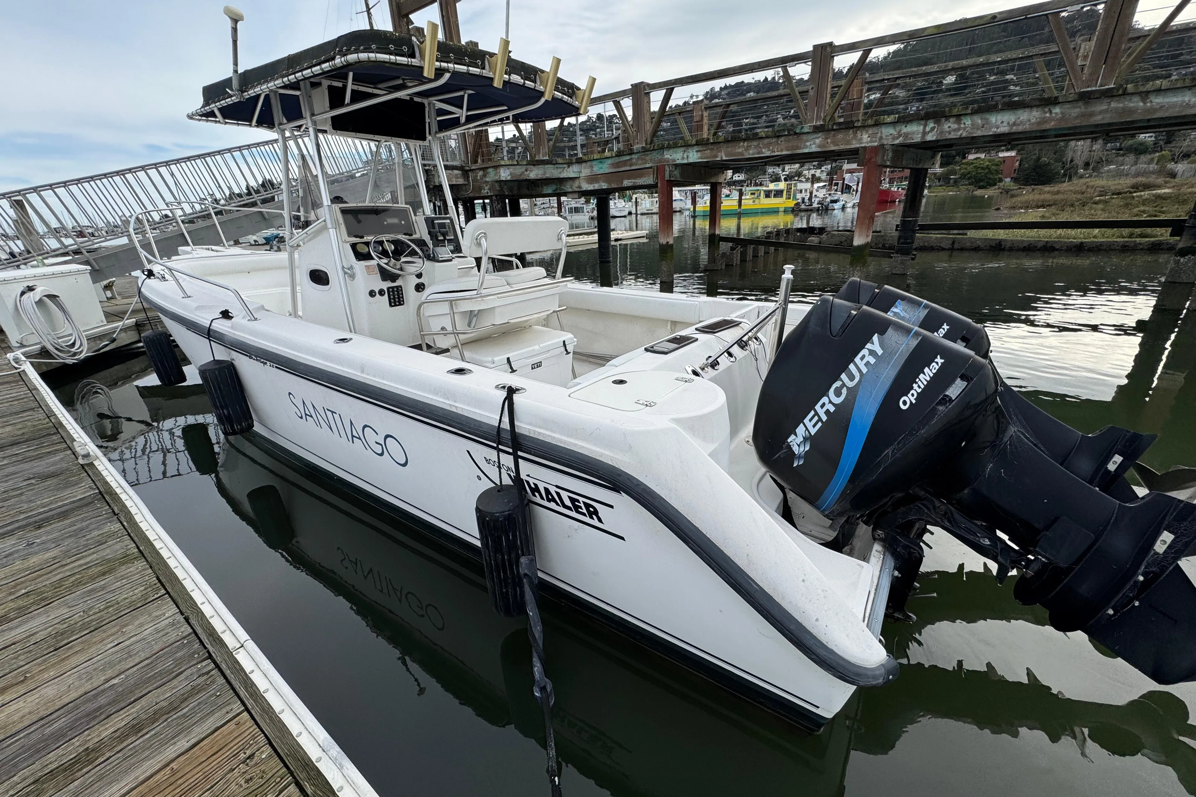 2001 Boston Whaler 26 Outrage boat docked with Mercury outboard engine.