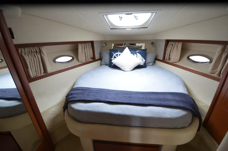  Yacht Photos Pics Luxurious cabin interior of 2007 Sea Ray 38 Sundancer yacht with cozy bed and porthole windows.