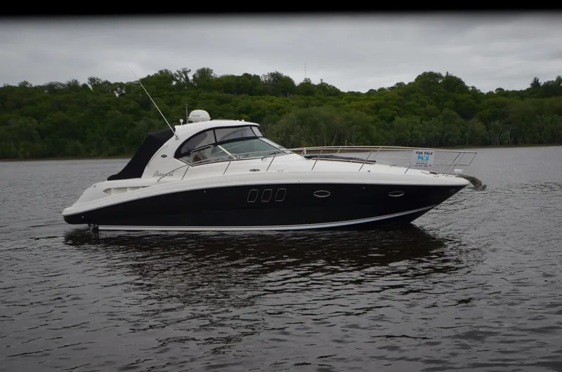  Yacht Photos Pics 2007 Sea Ray 38 Sundancer yacht on a calm river with lush green forest backdrop.