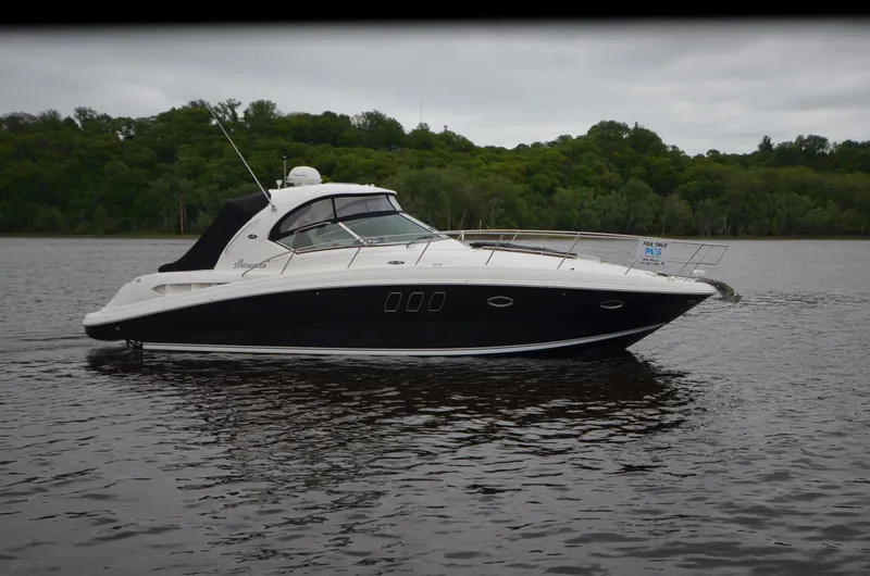  Yacht Photos Pics 2007 Sea Ray 38 Sundancer yacht on calm water with lush green forest background.