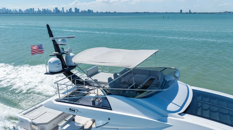 Swaha Yacht Photos Pics Azimut S7 2018 yacht cruising on blue waters with city skyline in background.