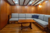 Luxurious 1929 Camper & Nicholsons J Class yacht interior with elegant wood paneling and cozy seating.