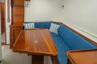 Interior of 1929 Camper & Nicholsons J Class yacht with blue seating and wooden table.