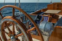 Wooden helm of 1929 Camper & Nicholsons J Class yacht on open sea.