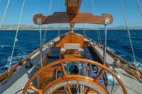 1929 Camper & Nicholsons J Class yacht, wooden deck, steering wheel, sailing on open sea.