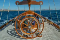 Wooden helm of 1929 Camper & Nicholsons J Class yacht on open sea.