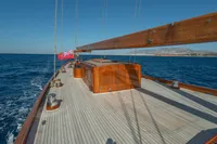 1929 Camper & Nicholsons J Class yacht sailing on open sea with wooden deck.