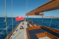 1929 Camper & Nicholsons J Class yacht sailing on open sea with clear blue skies.