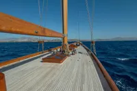 1929 Camper & Nicholsons J Class yacht sailing on open sea under clear blue sky.