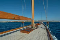 1929 Camper & Nicholsons J Class yacht sailing on open sea under clear blue sky.
