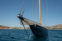 1929 Camper & Nicholsons J Class yacht on calm blue sea, clear sky background.