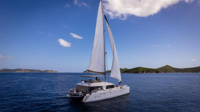 Copper Penny Yacht Photos Pics Sailing Lagoon 560 catamaran on open sea, 2011 model, with scenic island backdrop.