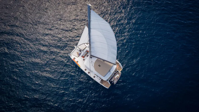 Copper Penny Yacht Photos Pics Aerial view of 2011 Lagoon 560 catamaran sailing on open sea.