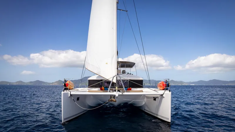 Copper Penny Yacht Photos Pics 2011 Lagoon 560 catamaran sailing on open sea under clear blue sky.