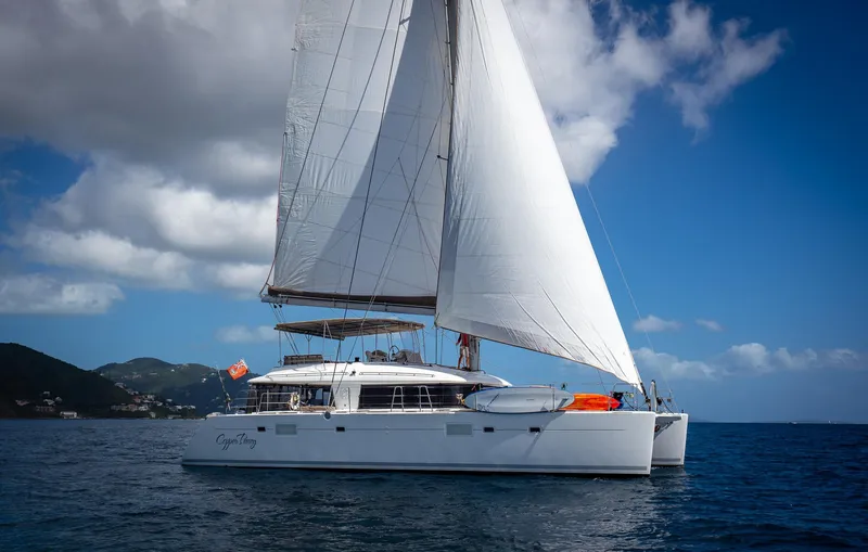 Copper Penny Yacht Photos Pics Sailing yacht Lagoon 560, 2011 model, cruising on open sea under clear blue sky.