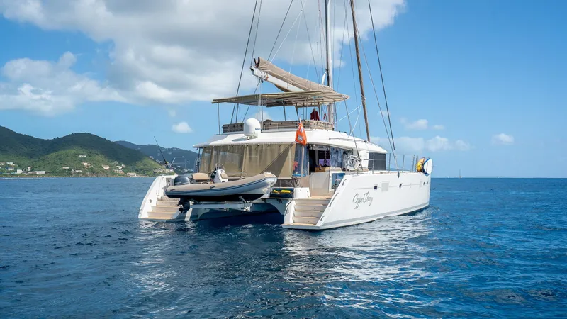 Copper Penny Yacht Photos Pics Lagoon 560 catamaran from 2011 on calm blue sea with scenic coastline.