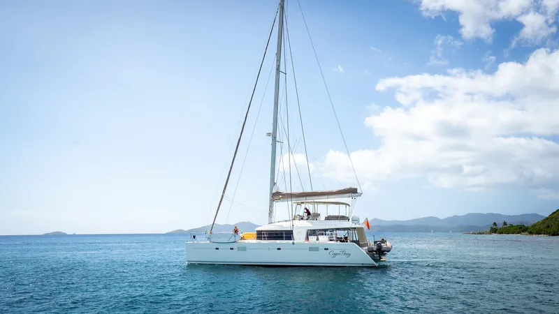 Copper Penny Yacht Photos Pics Sailing catamaran Lagoon 560, 2011 model, cruising in clear blue waters under a sunny sky.