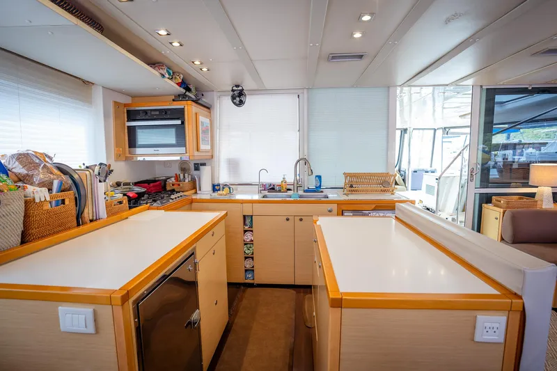 Copper Penny Yacht Photos Pics Modern kitchen interior on a 2011 Lagoon 560 yacht, featuring sleek countertops and ample storage.