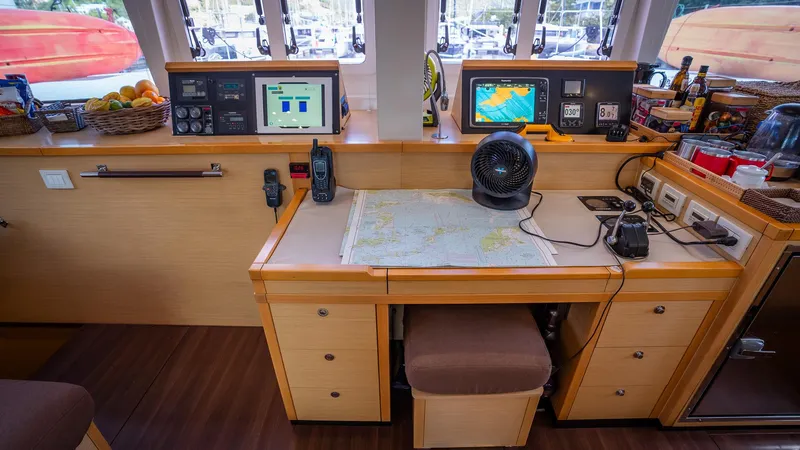 Copper Penny Yacht Photos Pics Navigation station of 2011 Lagoon 560 yacht with maps, electronics, and communication devices.