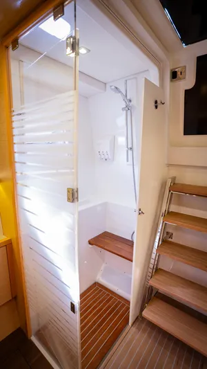 Copper Penny Yacht Photos Pics Luxurious shower area in a 2011 Lagoon 560 yacht with wooden accents and modern design.