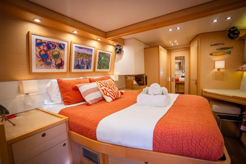Copper Penny Yacht Photos Pics Luxurious cabin interior of 2011 Lagoon 560 yacht with vibrant decor and cozy bedding.