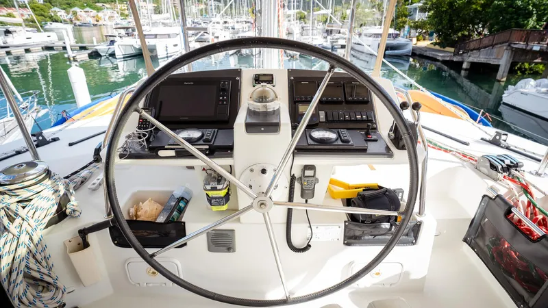 Copper Penny Yacht Photos Pics Steering wheel and controls of a 2011 Lagoon 560 yacht in a marina setting.