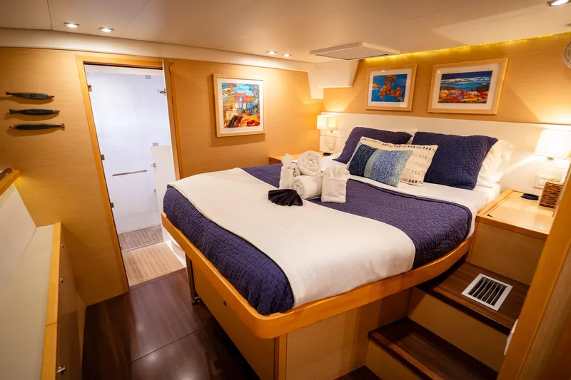 Copper Penny Yacht Photos Pics Luxurious cabin interior of 2011 Lagoon 560 yacht with cozy bed and elegant decor.