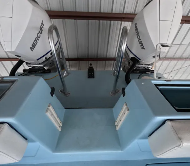 Cool Change Yacht Photos Pics 2022 Eastward 30 boat with dual Mercury outboard engines in a covered storage area.