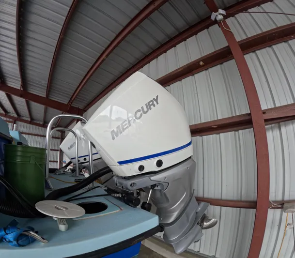 Cool Change Yacht Photos Pics Outboard motor on 2022 Eastward 30 boat in a metal-roofed storage area.