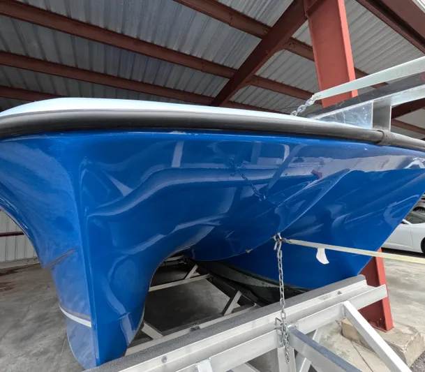 Cool Change Yacht Photos Pics Blue Eastward 30 boat hull, 2022 model, on a trailer in a covered storage area.